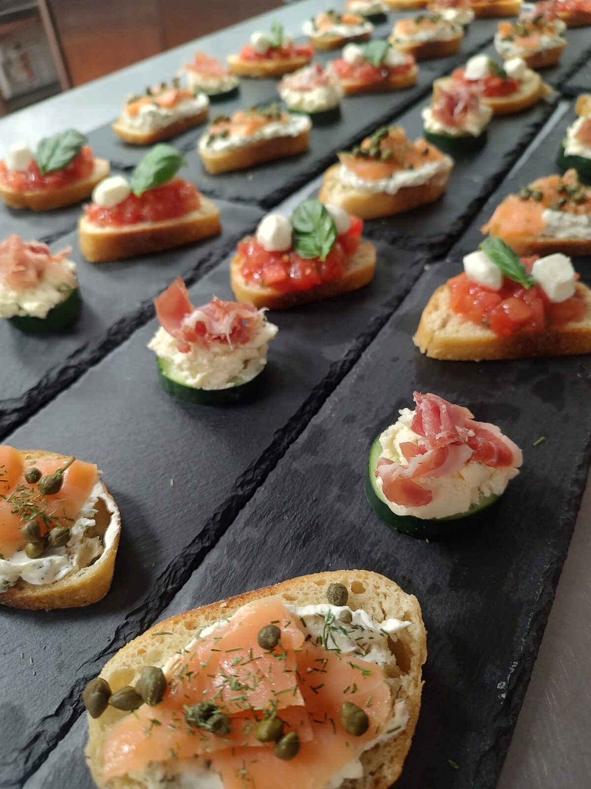 Trays of finished canapés arranged for service, garnished by hand