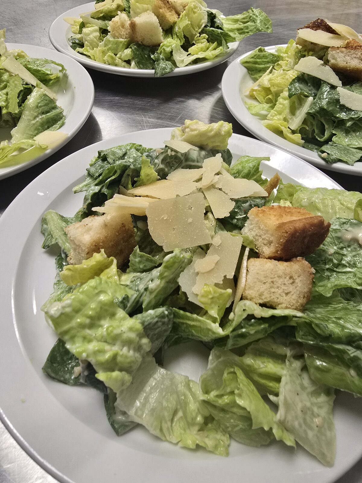 A Caesar salad tossed with shaved parmesan and golden croutons