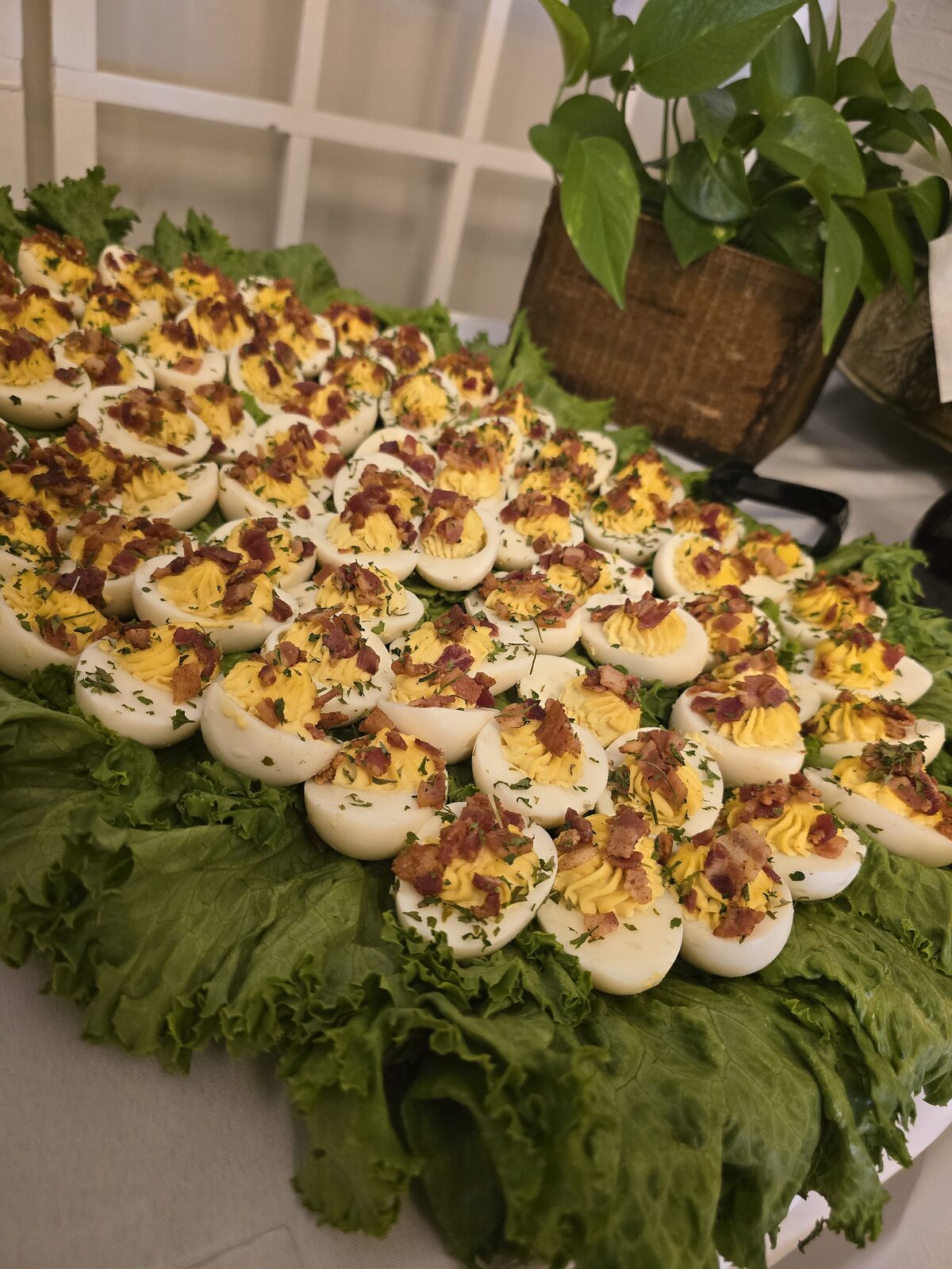A platter of deviled eggs piped high and finished with paprika and fresh herbs