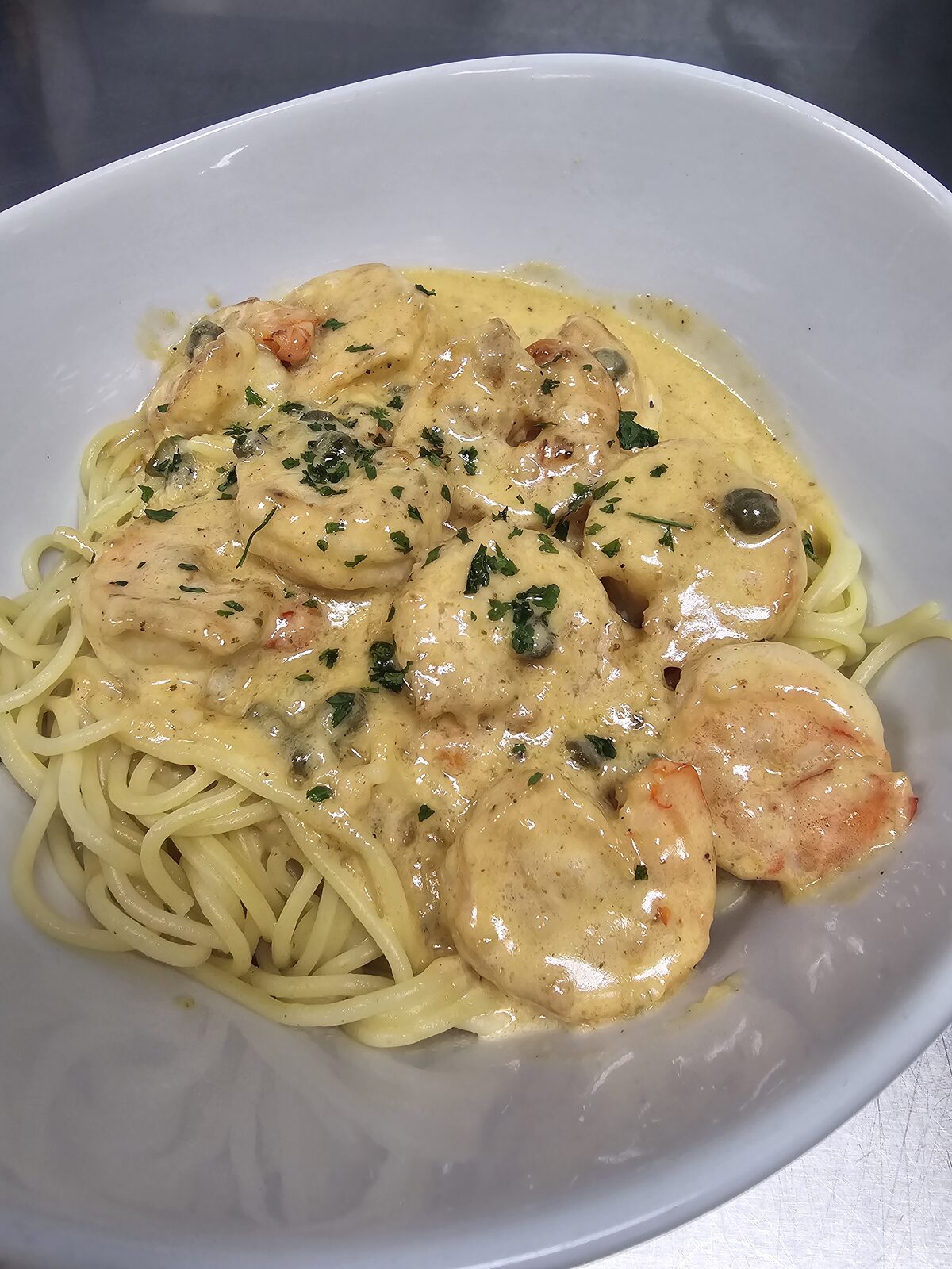 Plump shrimp in a creamy Cajun caper sauce, served over a nest of spaghetti